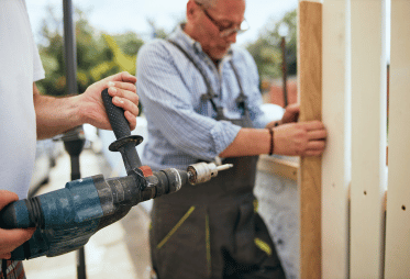 Two handymen repairing a fence